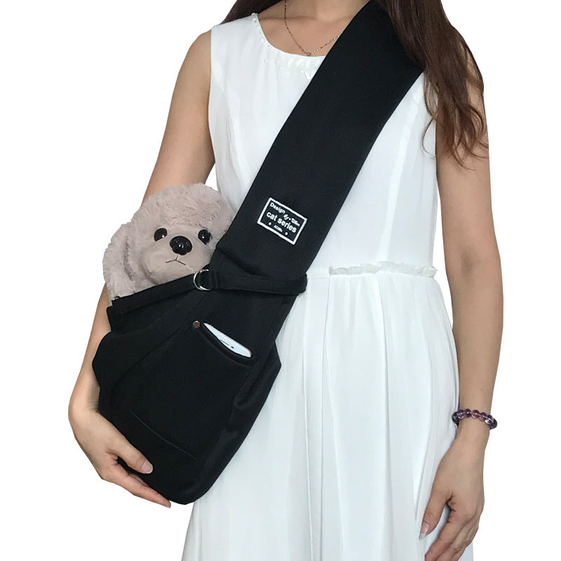 Grey pet sling shoulder bag carrying a small dog