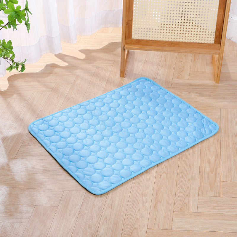 Dog lying on a grey non-slip cooling mat in summer