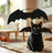Cat wearing black felt bat wings for Halloween