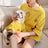 Small dog wearing a striped cotton T-shirt in blue